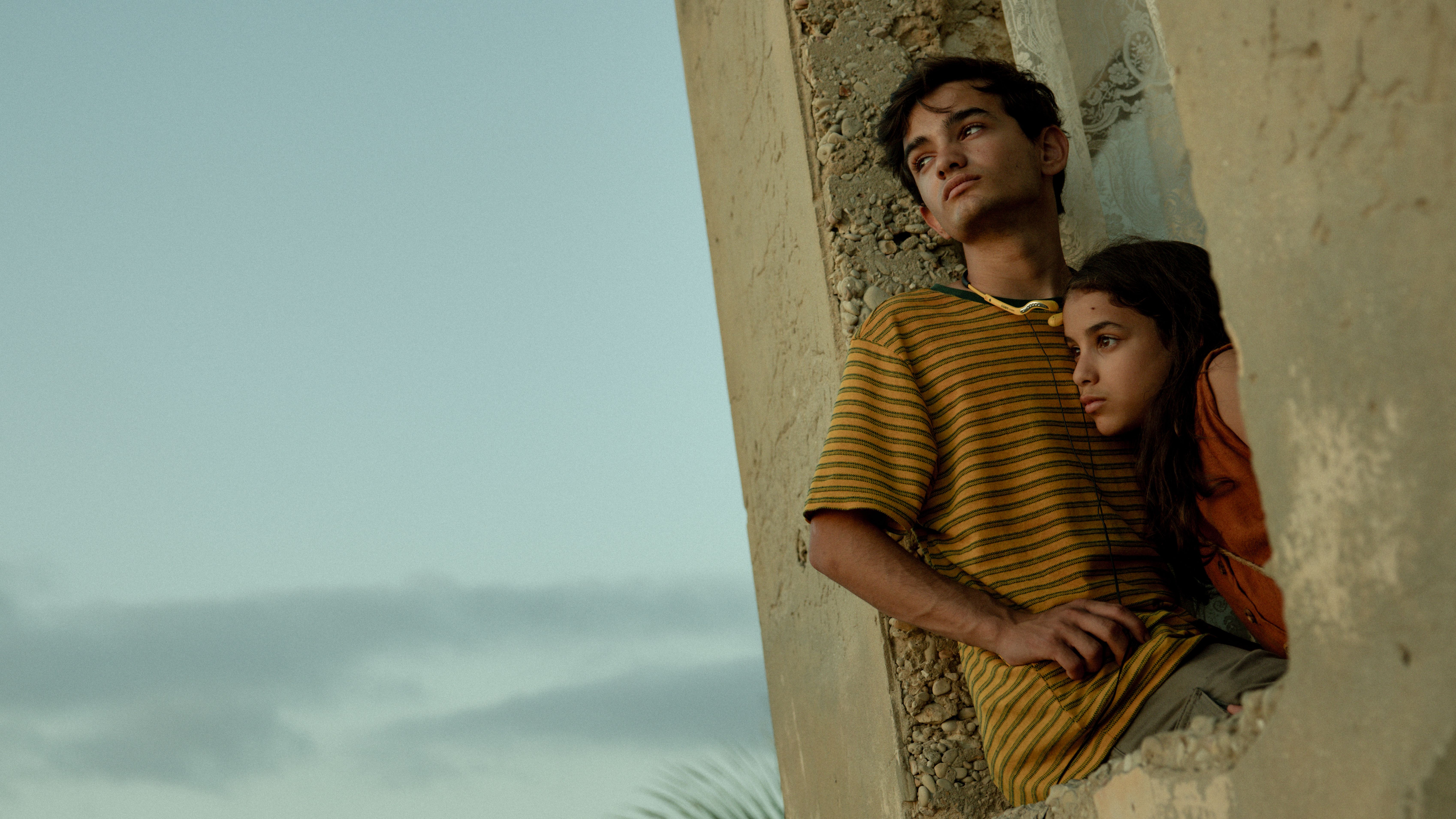 Adam (Zain Al Rafeea) ve Jana (Riman Al Rafeea) Netflix'in penceresinden dışarı bakıyor "Kumdan Kale"