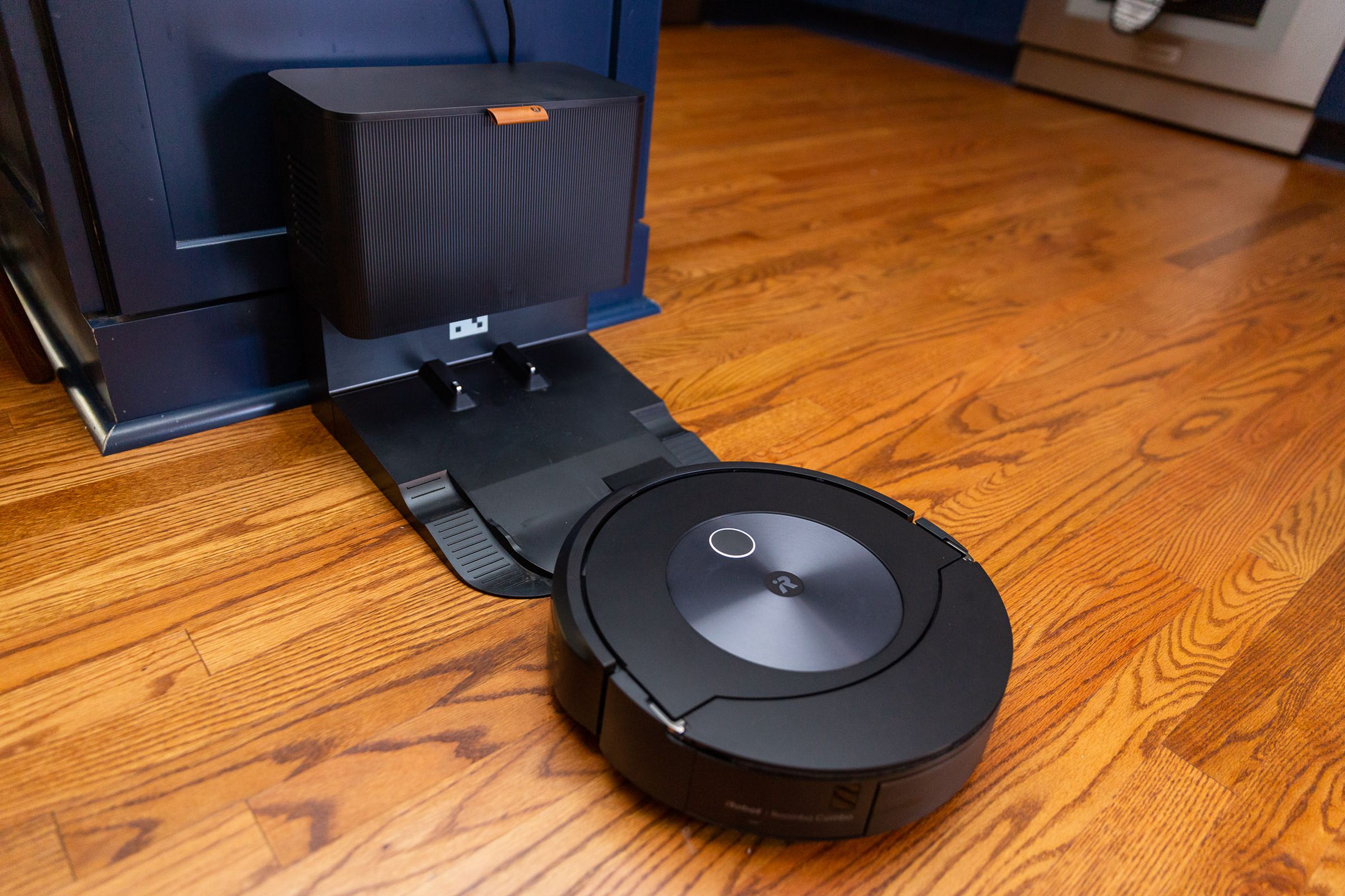 Odaya boş üssüne yaklaşan Roomba Combo J7 fotoğrafı. Taban, küçük bir mutfak çöp kutusunun büyüklüğündedir.