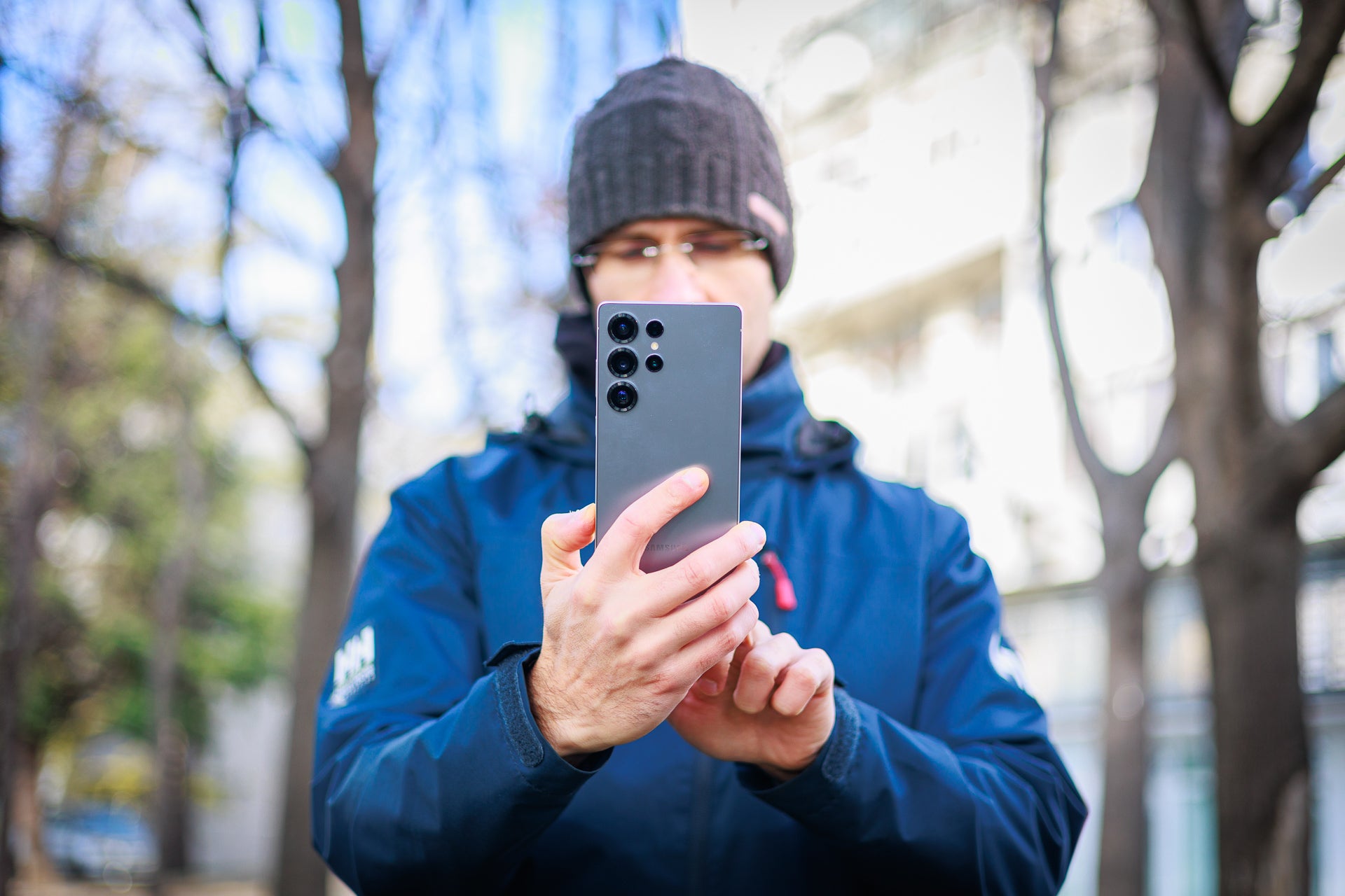 Çerçevenin ortasındaki adam, bir telefon tutma ve kullanma.