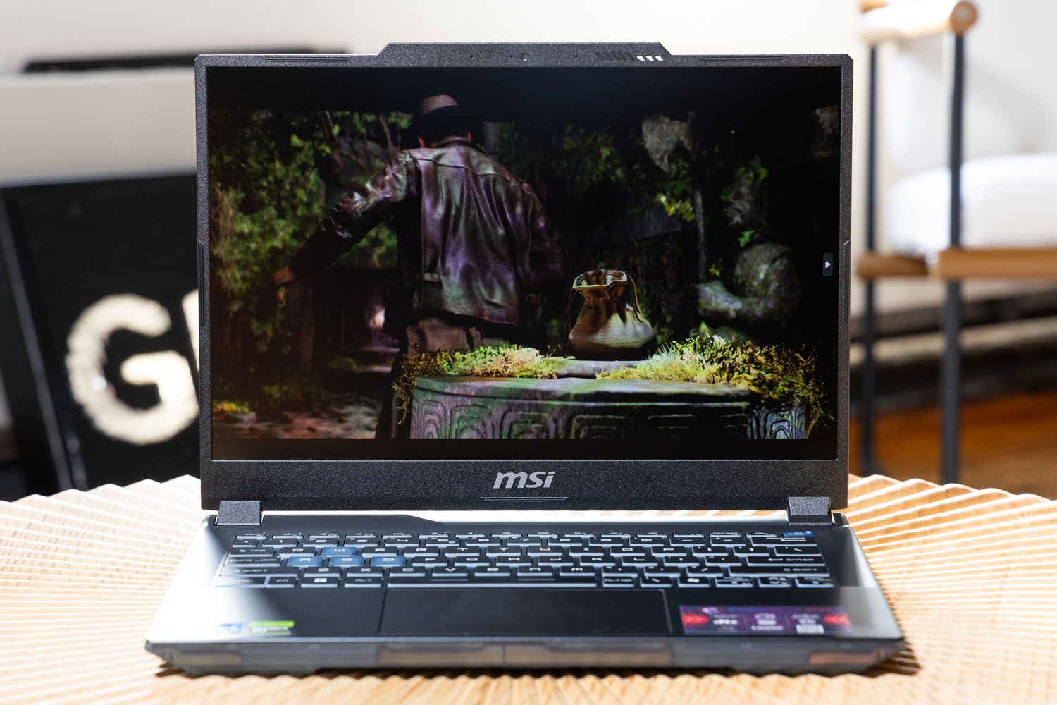 Indiana Jones'dan sahne ve MSI Cyborg 14'ün ekranındaki Great Circle