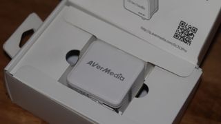 AVerMedia Elite Go GC313 Pro şarj ünitesi ve beyaz renkli yakalama kartı kombinasyonu.