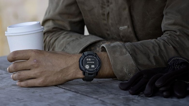 Bir kişi bilekte Garmin Instinct 2x güneş saati ile bir kahve kupası tutar. Bir kişi bilekte Garmin Instinct 2x güneş saati ile bir kahve kupası tutar.