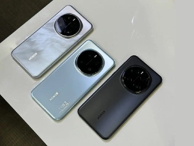 Bir masada görüntülenen farklı renklerde üç Honor Magic 7 Pro akıllı telefon.