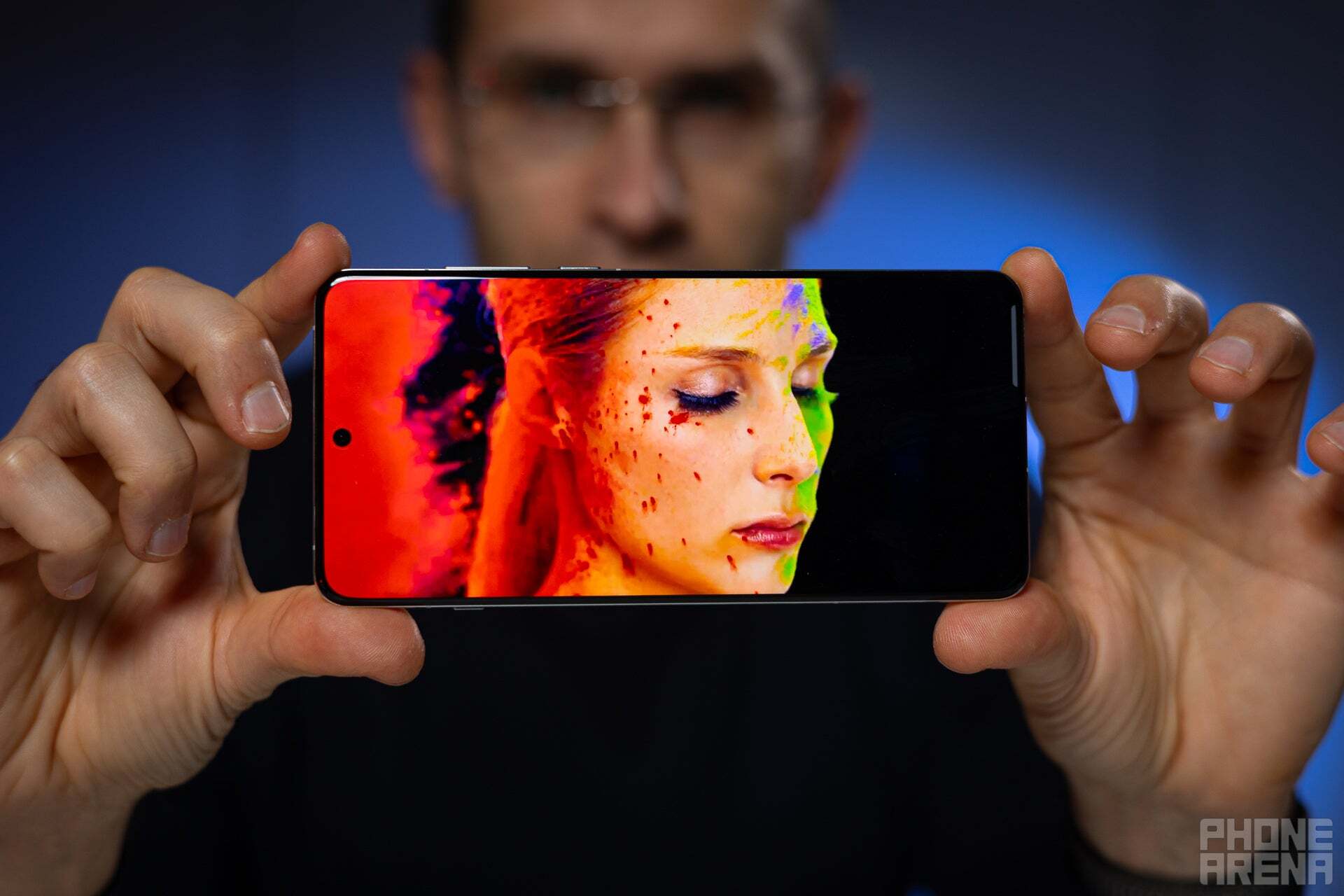 OnePlus 13'ü tutan bir kişi ekranını gösteriyor.