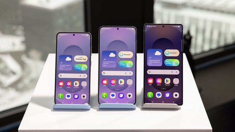 Farklı başlangıç ​​ekran düzenleri gösteren standlarda üç Samsung Galaxy S25 cep telefonu.