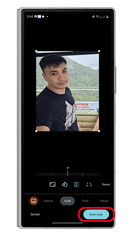 Arka planda dağlarla bir selfie yapan ve fotoğrafı Google fotoğraflarında düzenleyen bir kişi.