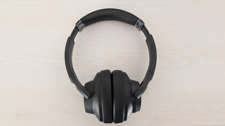 Black Anchor Soundcore Q20I hafif ahşap bir yüzeyde Bluetooth kulaklıklar.