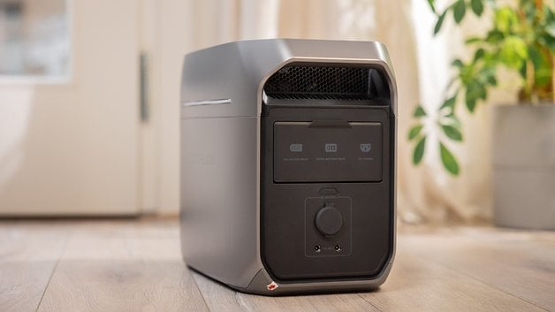 Bir bitkinin yanındaki ahşap bir zeminde ince bir EcoFlow Delta 3 artı taşınabilir elektrik jeneratörü.