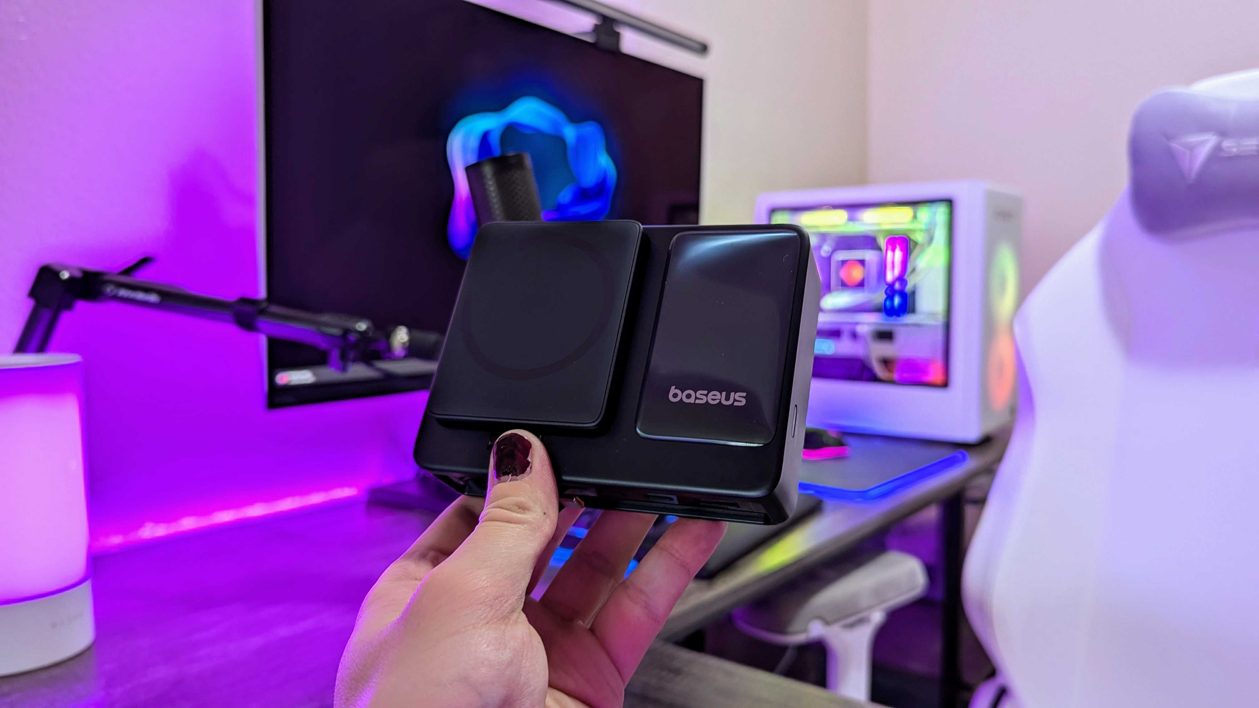 Baseus Nomos 5-in-1'de masaüstü şarj cihazı bir elinde tutuldu.