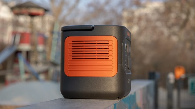 Bir Jackery Explorer 2000 elektrik santrali, bir oyun alanı olan bir kenarda arka planda duruyor.