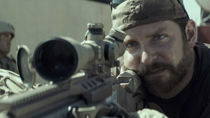 Bradley Cooper, Amerikan keskin nişancıdan bir sahnede bir keskin nişancı tabancası tutarak çömeldi.