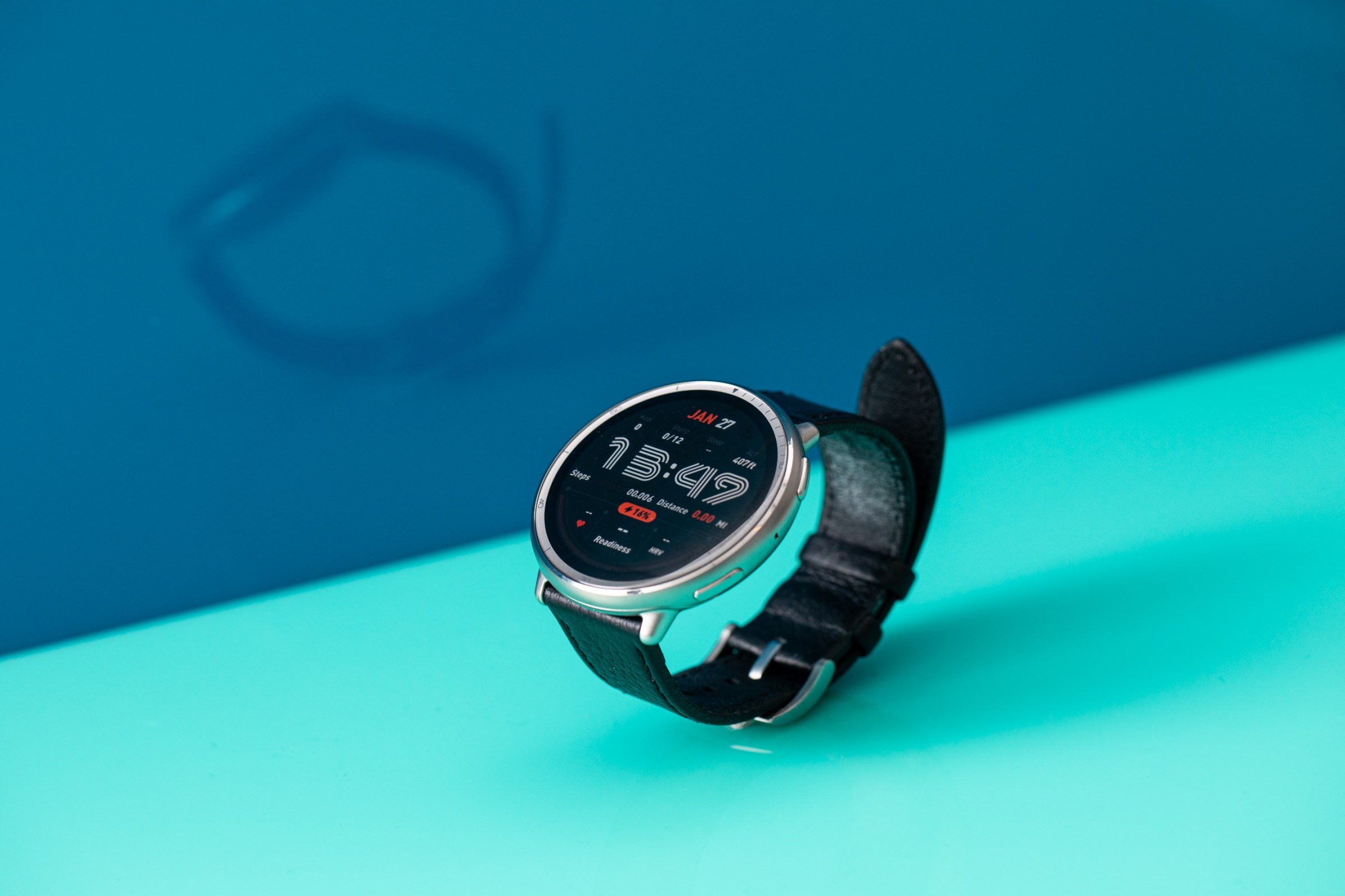 Parlak mavi bir arka plana karşı şık bir retro saat yüzünü gösteren Amazfit Active 2'nin açılı görünümü