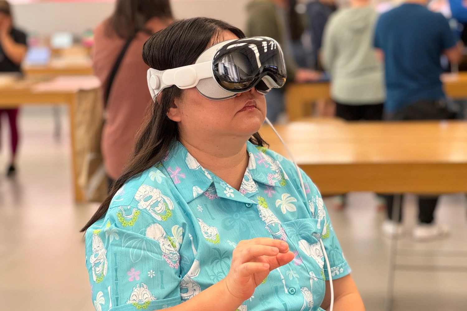 Apple mağazasında Apple Vision Pro Demo birimini giyen bir kişi.