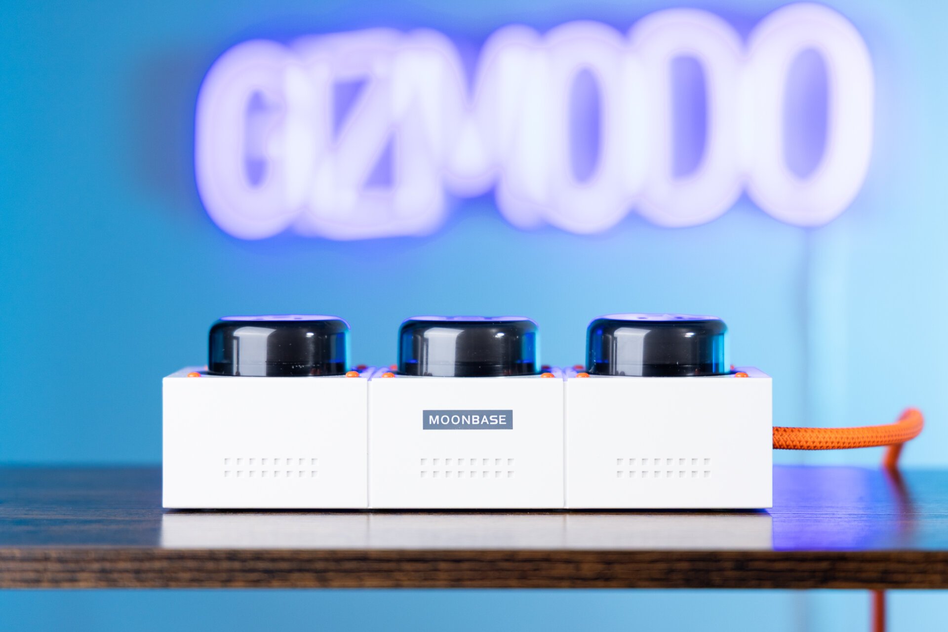 Genki Moonbase Power Strip Neon Gizmodo İşaretinin Önünde