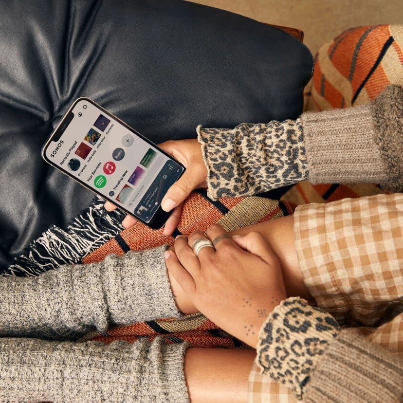 Sonos uygulamasıyla akıllı telefon tutan bir kişi açıldı.