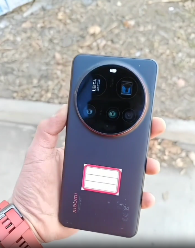 Leica lensleri içeren büyük dairesel kamera modülüne sahip siyah bir Xiaomi akıllı telefonu tutan bir kişi.