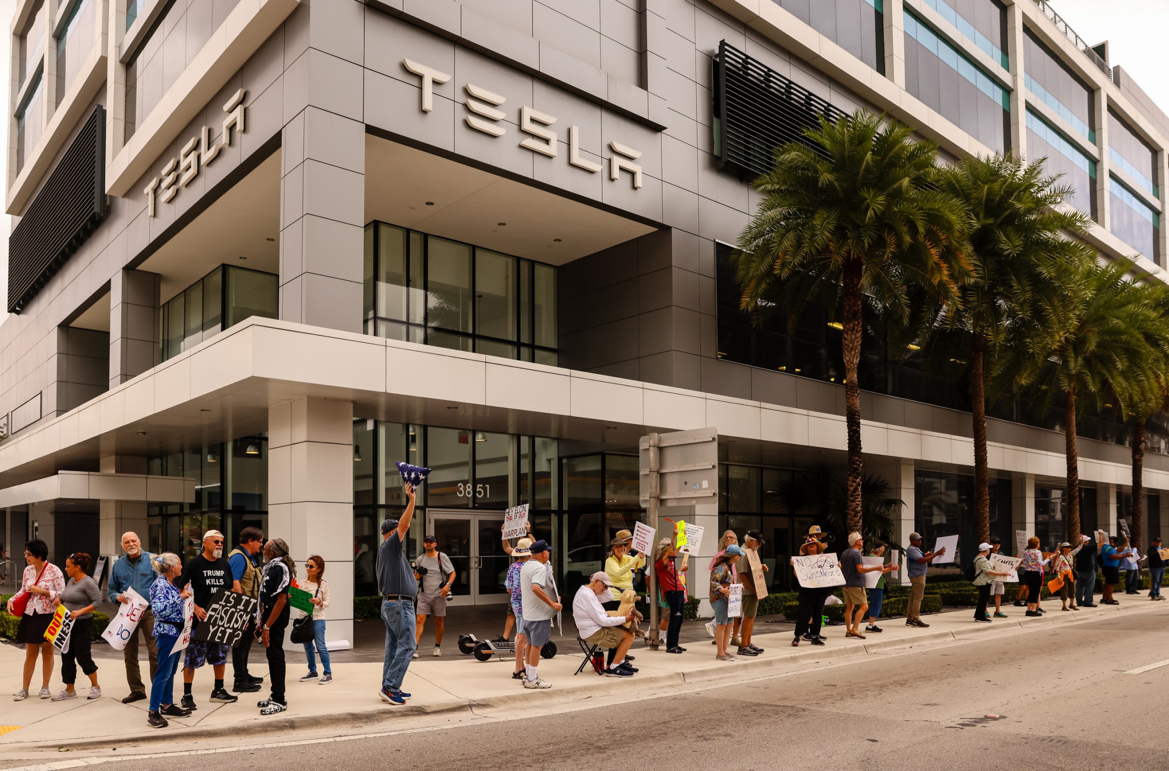 Protestocular, Miami'deki Coral Gables mahallesindeki bir Tesla showroomunda ülke çapında barışçıl bir protesto hareketi olan Tesla yayından kaldırma sırasında toplanıyor.