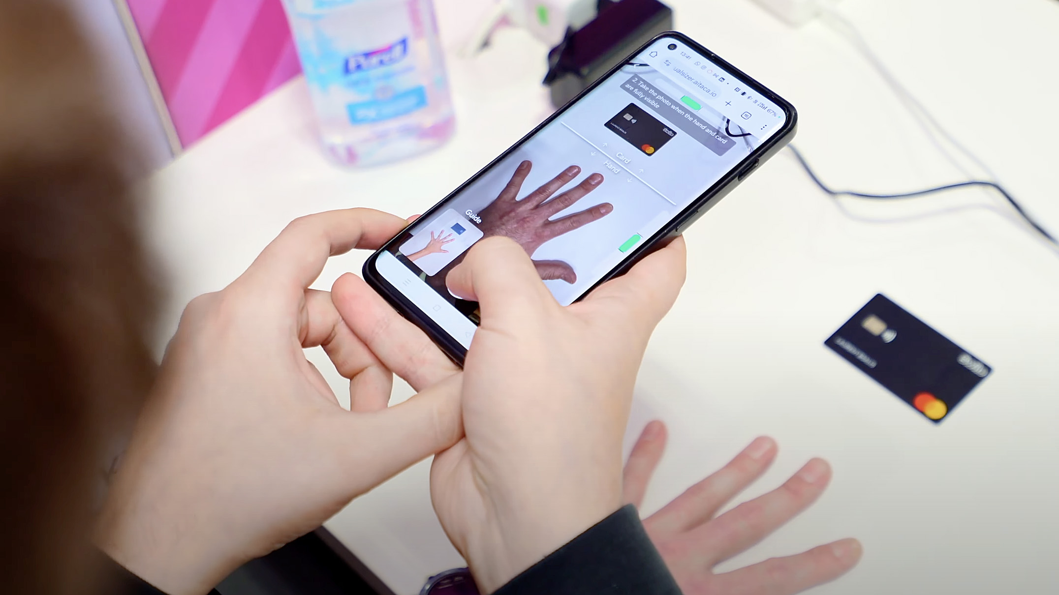 Kredi kartı büyüklüğünde bir plastik parçasının yanındaki bir akıllı telefon kamerasını gösteren bir kullanıcıyla Circular Ring 2'nin dijital boyutlandırma özelliğinin bir demosu