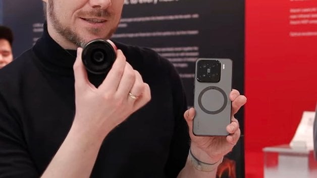 Bir kişi bir etkinlikte bir Xiaomi 15 konsept telefonu ve kamera lensi tutar.