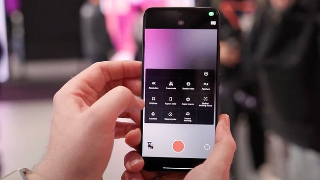 Bir el, video kaydı için kamera ayarlarını gösteren bir akıllı telefon tutar.