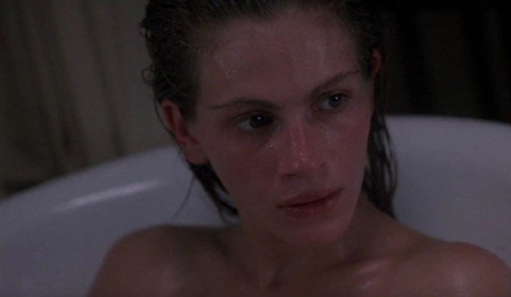 Julia Roberts bir küvette oturuyor ve bakıyor.