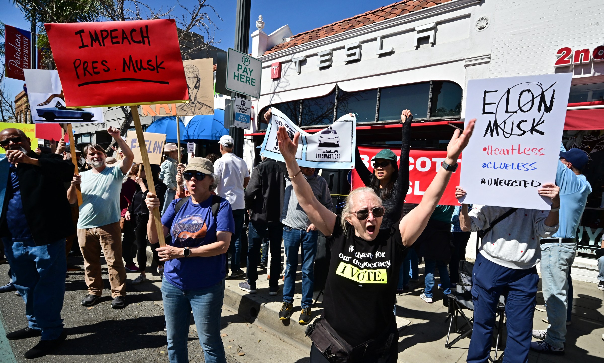 Protestocular Tesla'nın Pasadena bayisinin dışında toplanıyor.