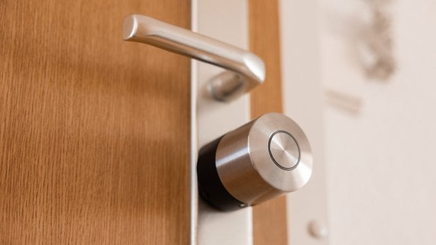Ahşap bir kapıya bağlı bir Nuki Smart Lock Pro'nun kapatılması.