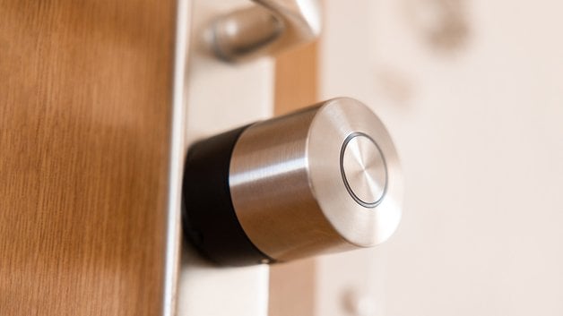 Ahşap bir kapıya monte edilmiş bir Nuki Smart Lock Pro.