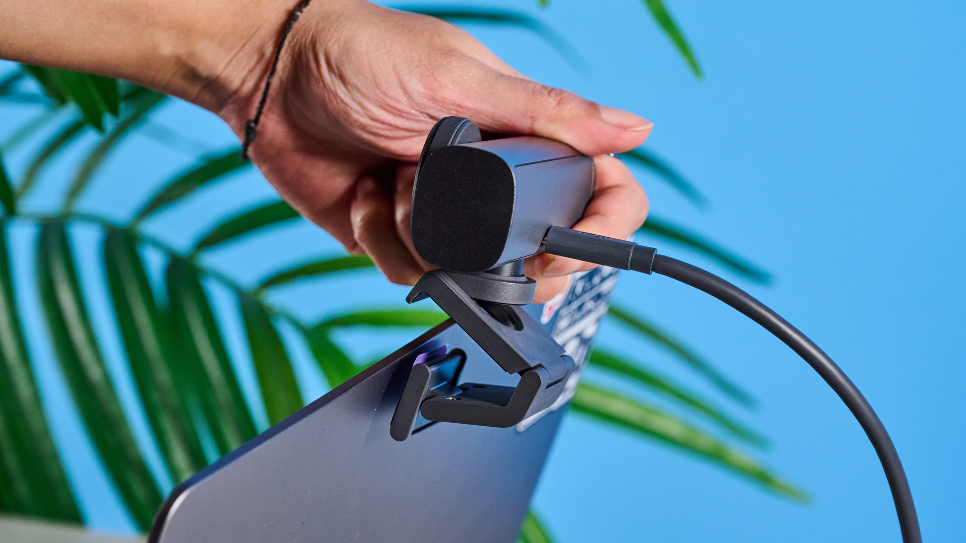 Mavi arka planın önünde resmedilen Logitech MX Brio 705