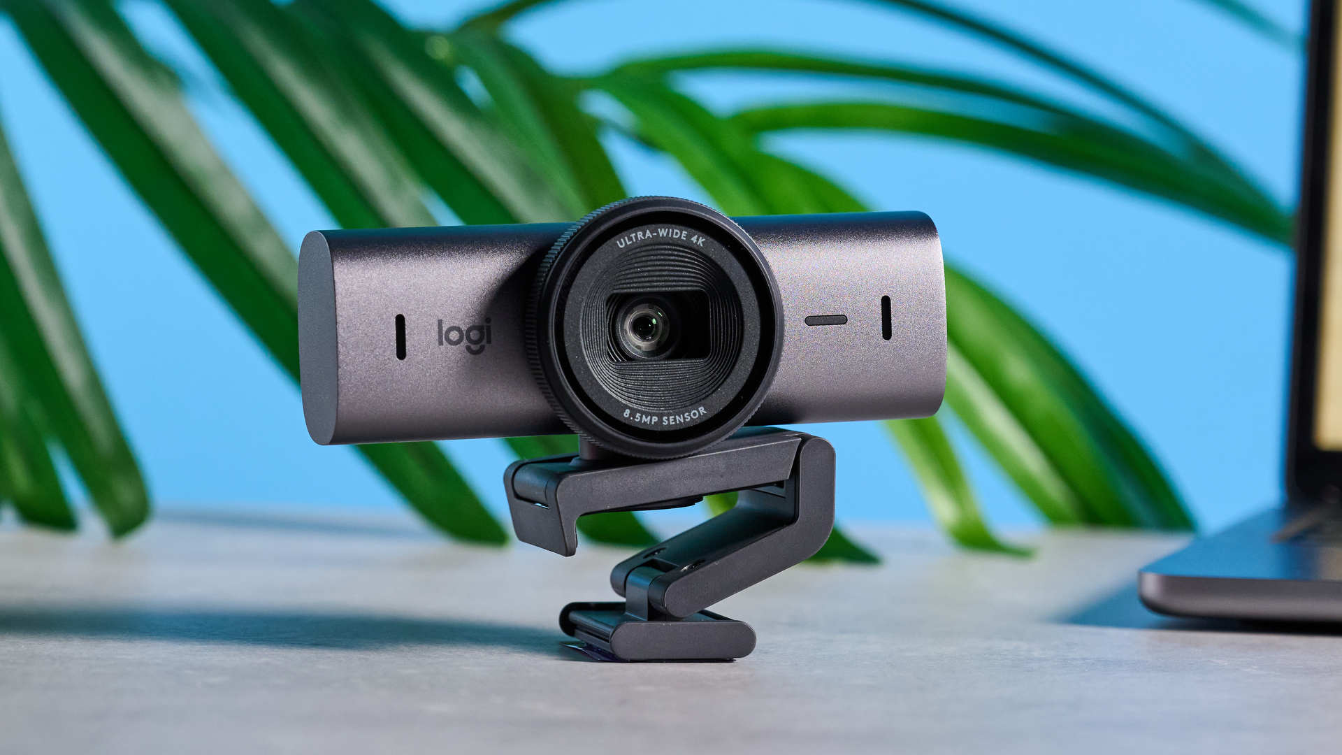 Mavi arka planın önünde resmedilen Logitech MX Brio 705