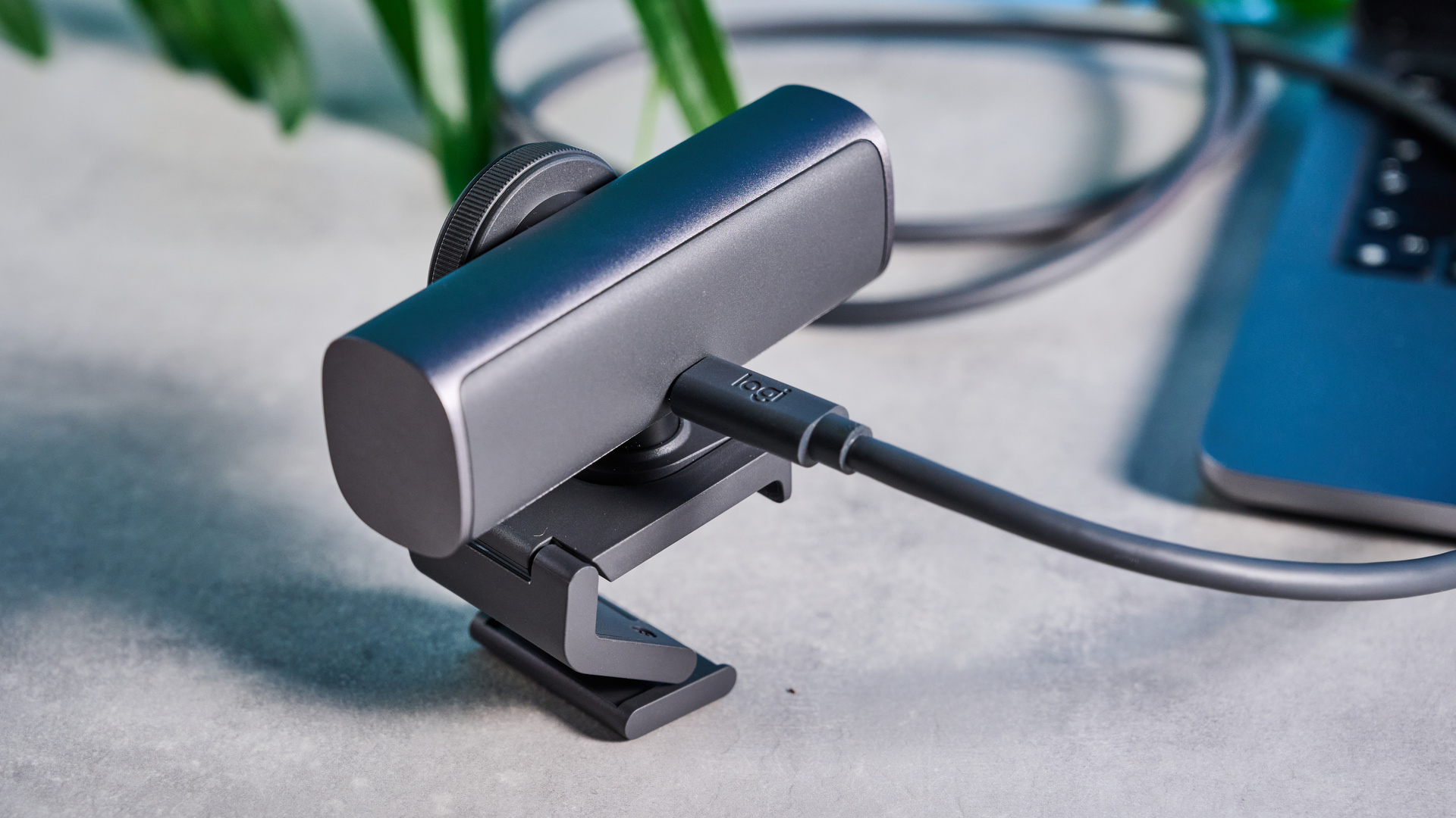 Mavi arka planın önünde resmedilen Logitech MX Brio 705