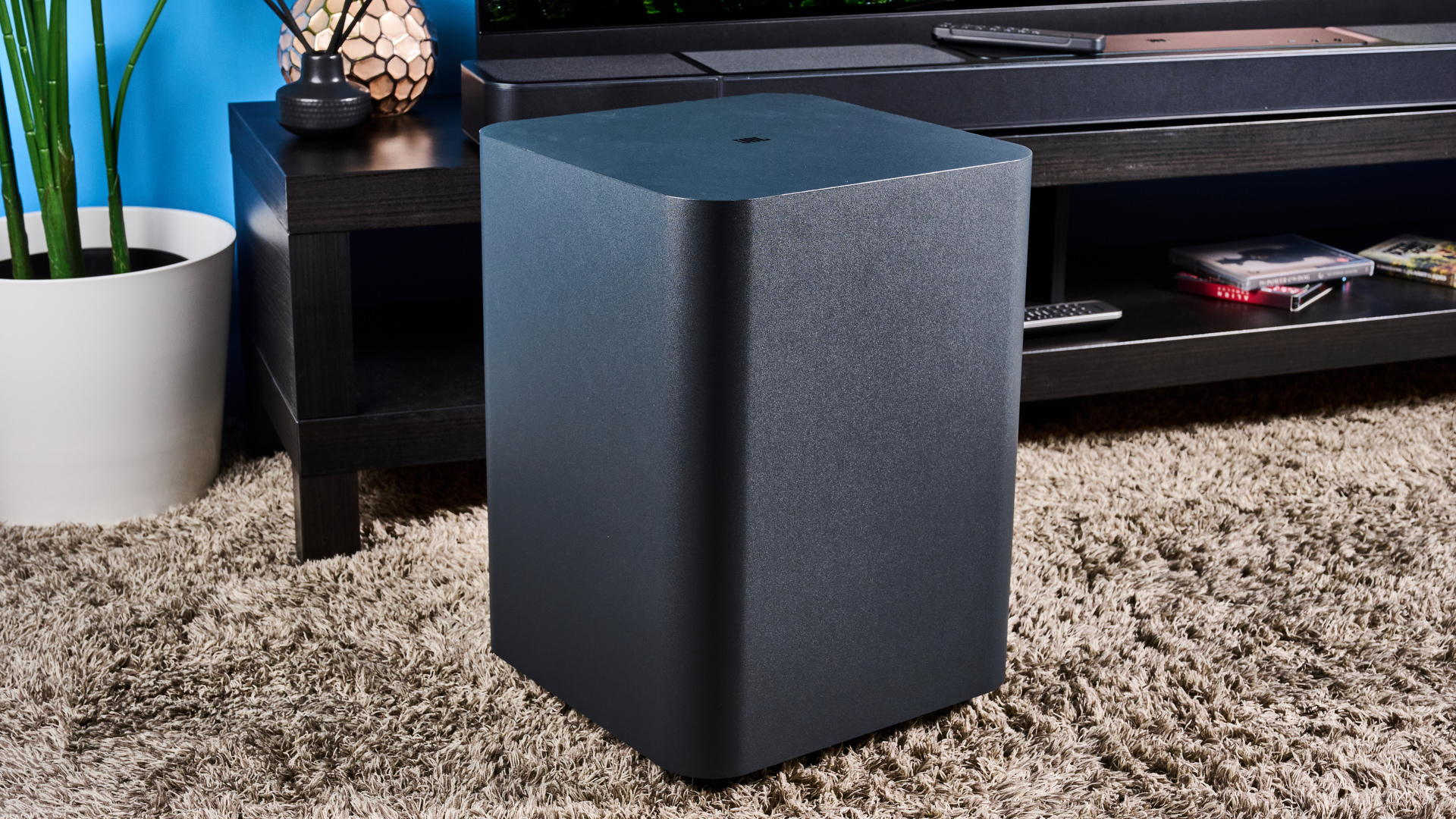 JBL çubuğu 1300x HDMI bağlantı noktaları olan siyah bir ses çubuğu, iki surround kanal hoparlör, kablosuz olarak bağlı bir subwoofer