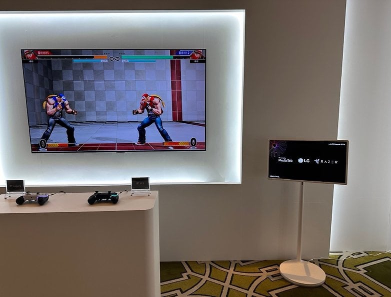 Kontrolörler önündeyken bir dövüş oyunu gösteren akıllı bir TV ile bir oyun kurulumu.