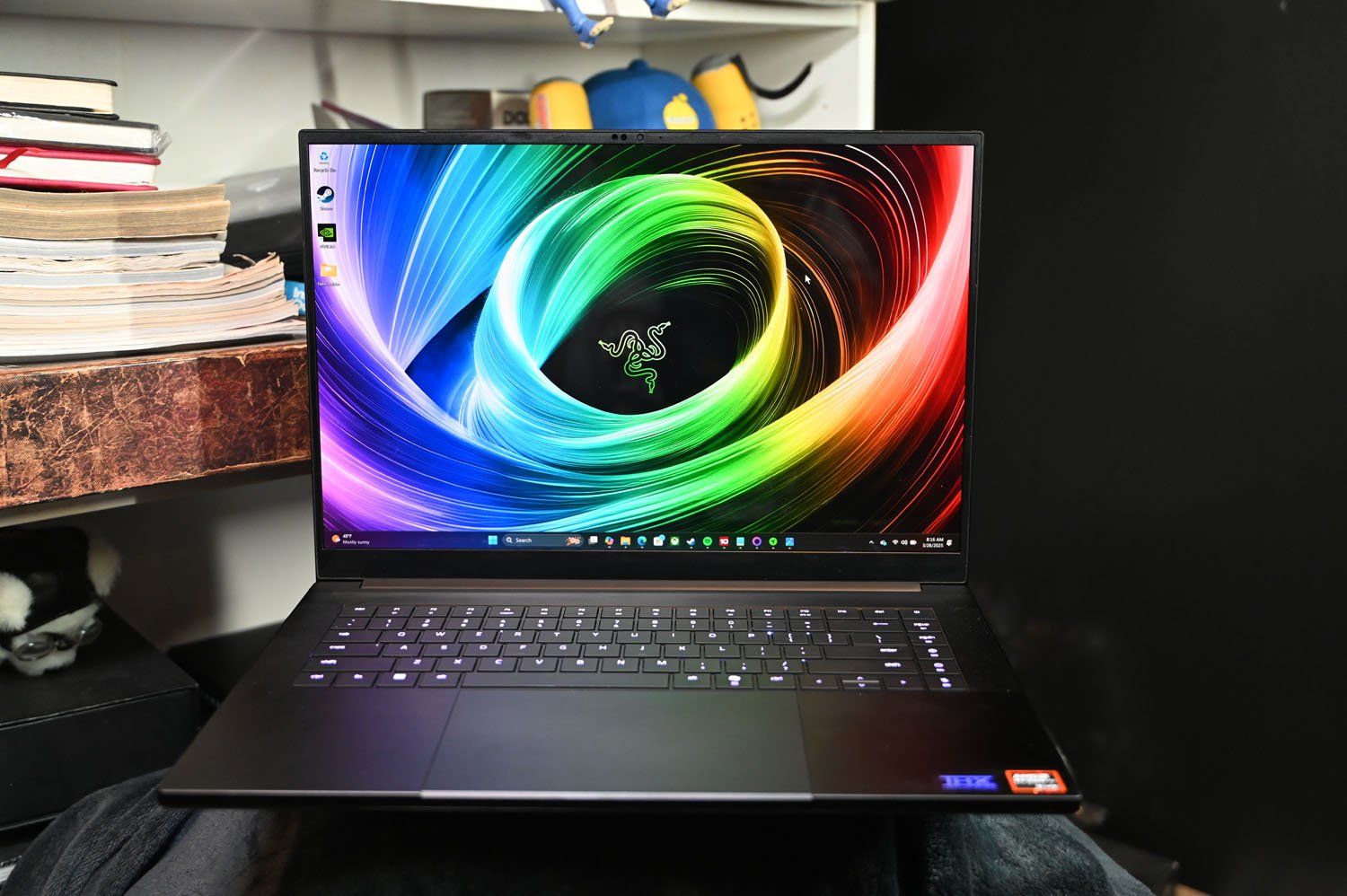 Beyaz Kitap Kılıfının Önünde Razer Blade 16 2025'in ön çekimi