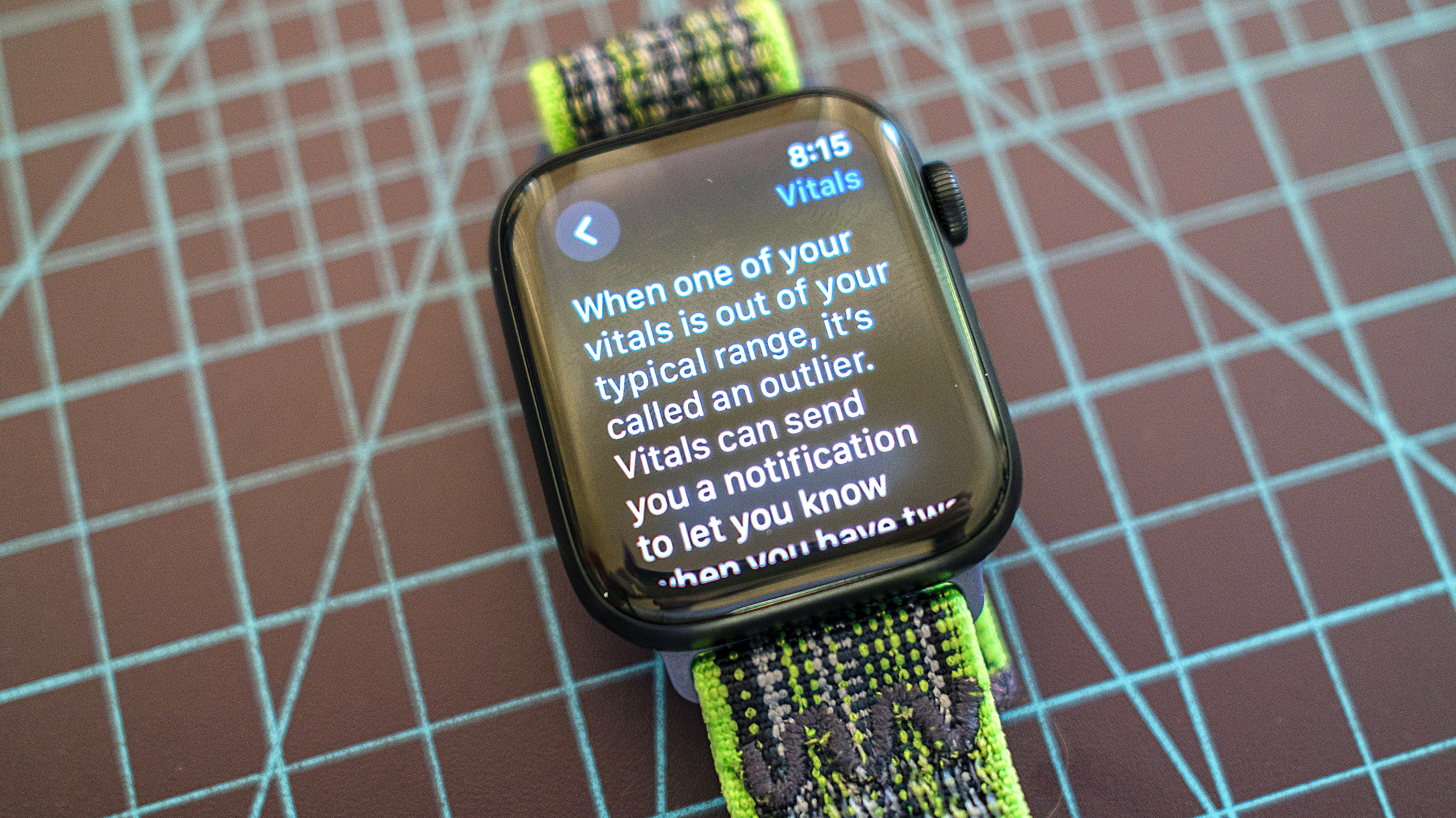 Apple Watch SE, Yeşil ve Gri Kumaş Kayışında Yeni Vitals uygulamasından ayrıntıları gösteriyor