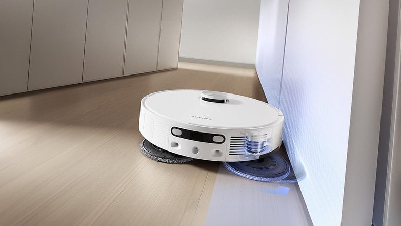 Bir Dream L10s Ultra Gen 2 emme robotu, bir duvarın yanında ahşap bir zemini temizler. Bir Dream L10s Ultra Gen 2 emme robotu, bir duvarın yanında ahşap bir zemini temizler.