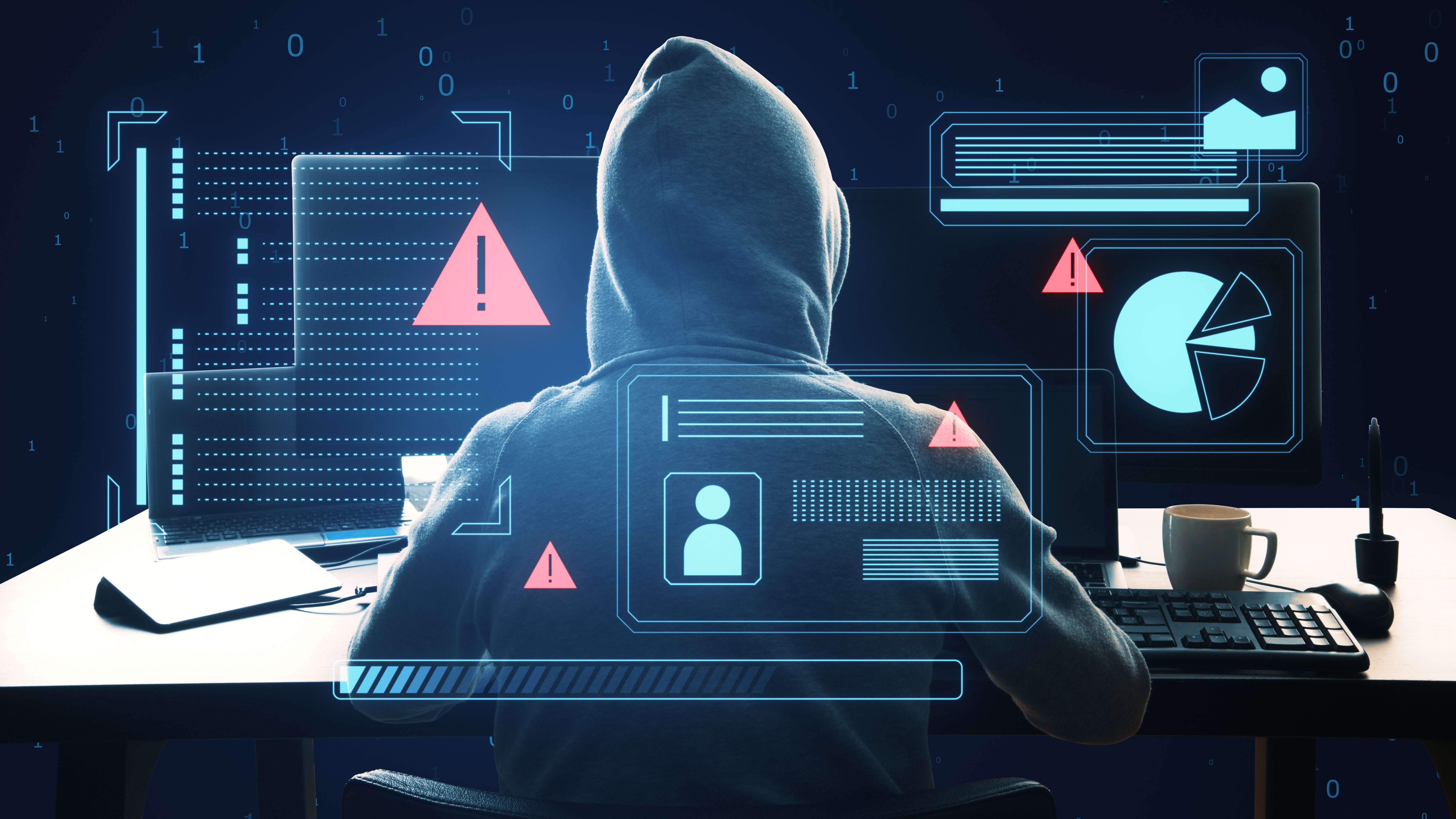 Bir bilgisayarda oturan bir kapüşon giyen bir hacker, yüzü gizlendi.