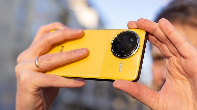 Bir kişi sarı bir Xiaomi F7 ultra akıllı telefona sahip ve fotoğraf çekmeye hazırlanıyor.