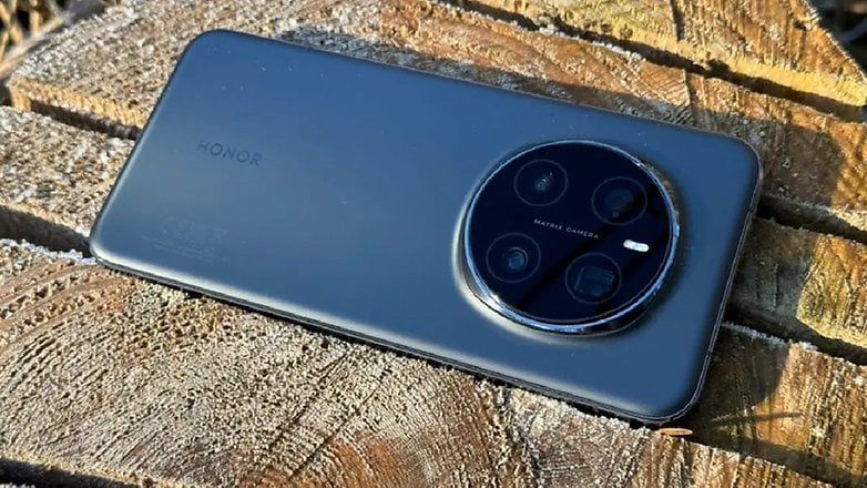 Ahşap bir yüzeyde yuvarlak kamera modülü olan Magic 7 Pro Smartphone'u onurlandırın.