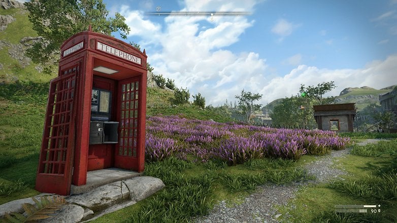 Kırmızı bir telefon kabini, bulutlu bir gökyüzünün altında mor çiçekleri olan çimenli bir alanda. Kırmızı bir telefon kabini, bulutlu bir gökyüzünün altında mor çiçekleri olan çimenli bir alanda.