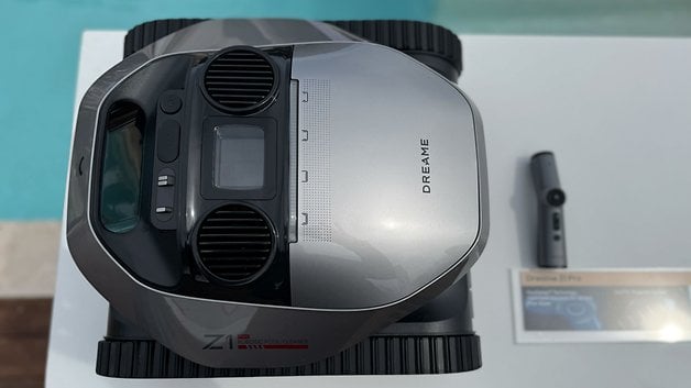 Yanında uzaktan kumanda bulunan bir masada havuz temizliği için bir rüya Z1 robotu.