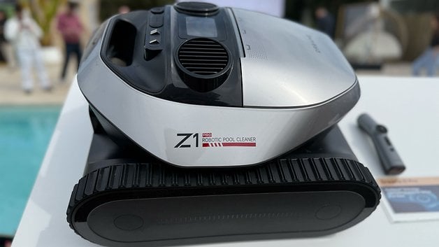 Uzaktan kumandanın yanında bir masada bir Dreate Z1 Pro Robot Havuz Temizleyici.