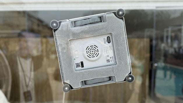 Bir cam yüzeye yapışan bir Dreate C1 pencere temizleme robotu.