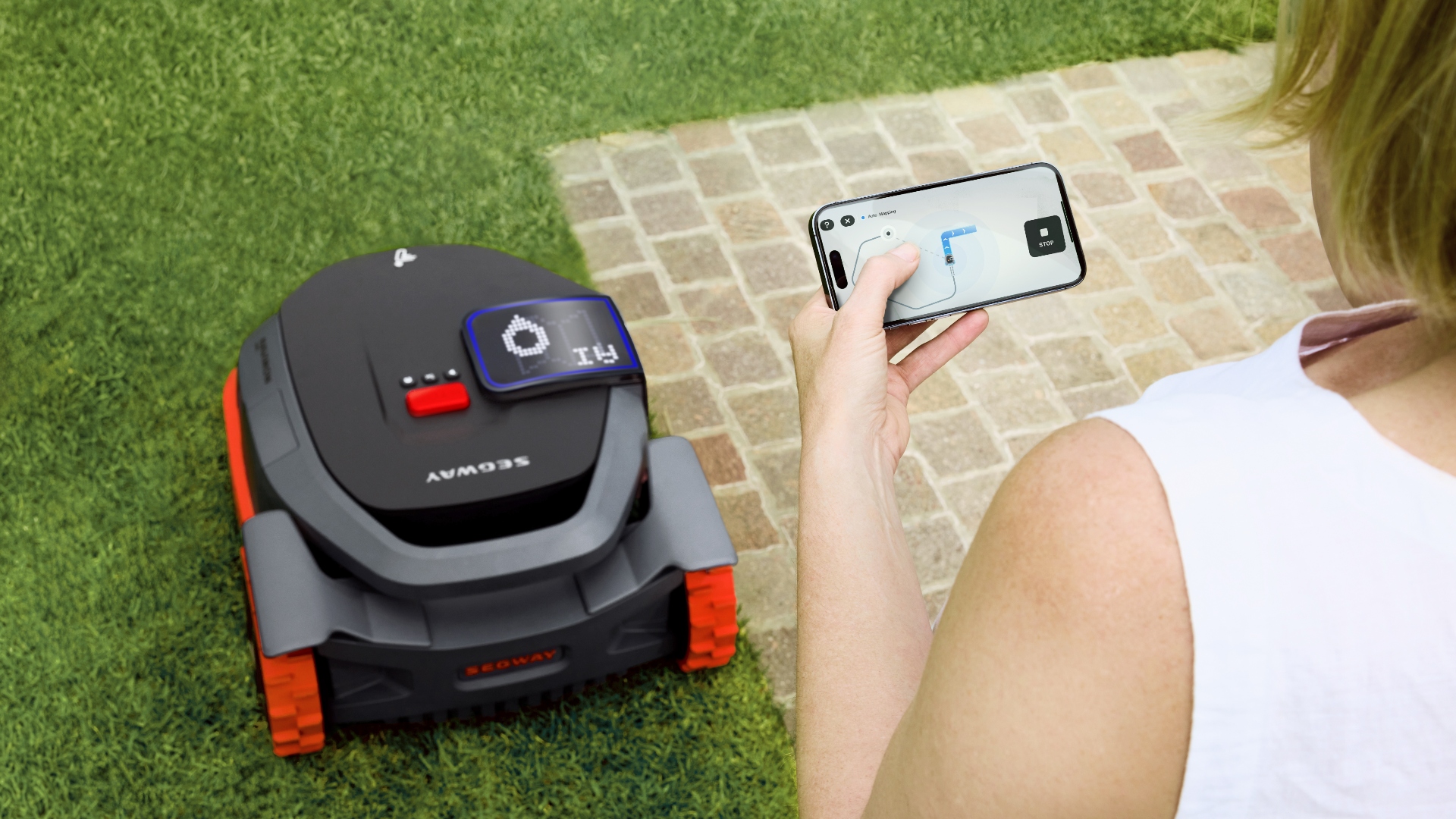 Segway Navimow X3 serisinde akıllı teknolojiyi kullanan bir kadın