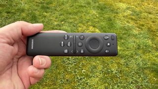 Samsung QN900F remote control held in hand