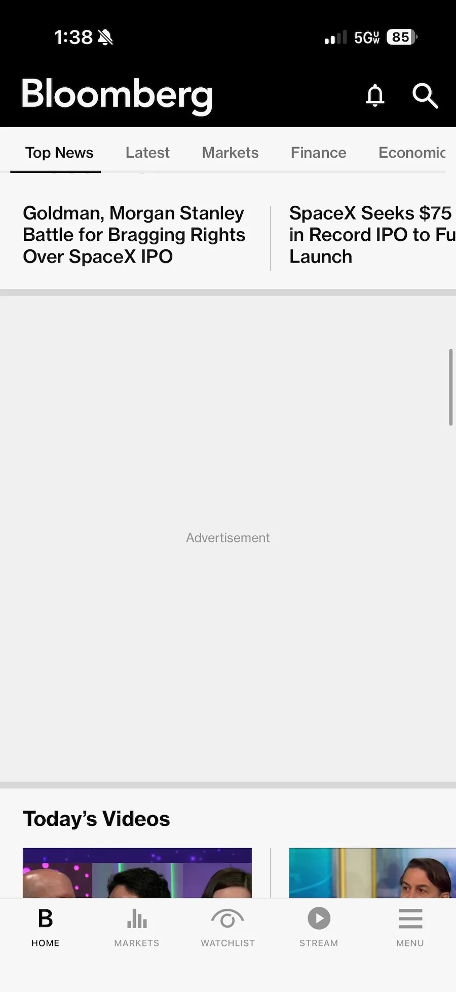 Bloomberg iOS uygulamasından bir ekran görüntüsü, reklamlar bloklanmış ve sadece "Reklam" kelimesinin yazılı olduğu gri bir dikdörtgen gösteriyor.