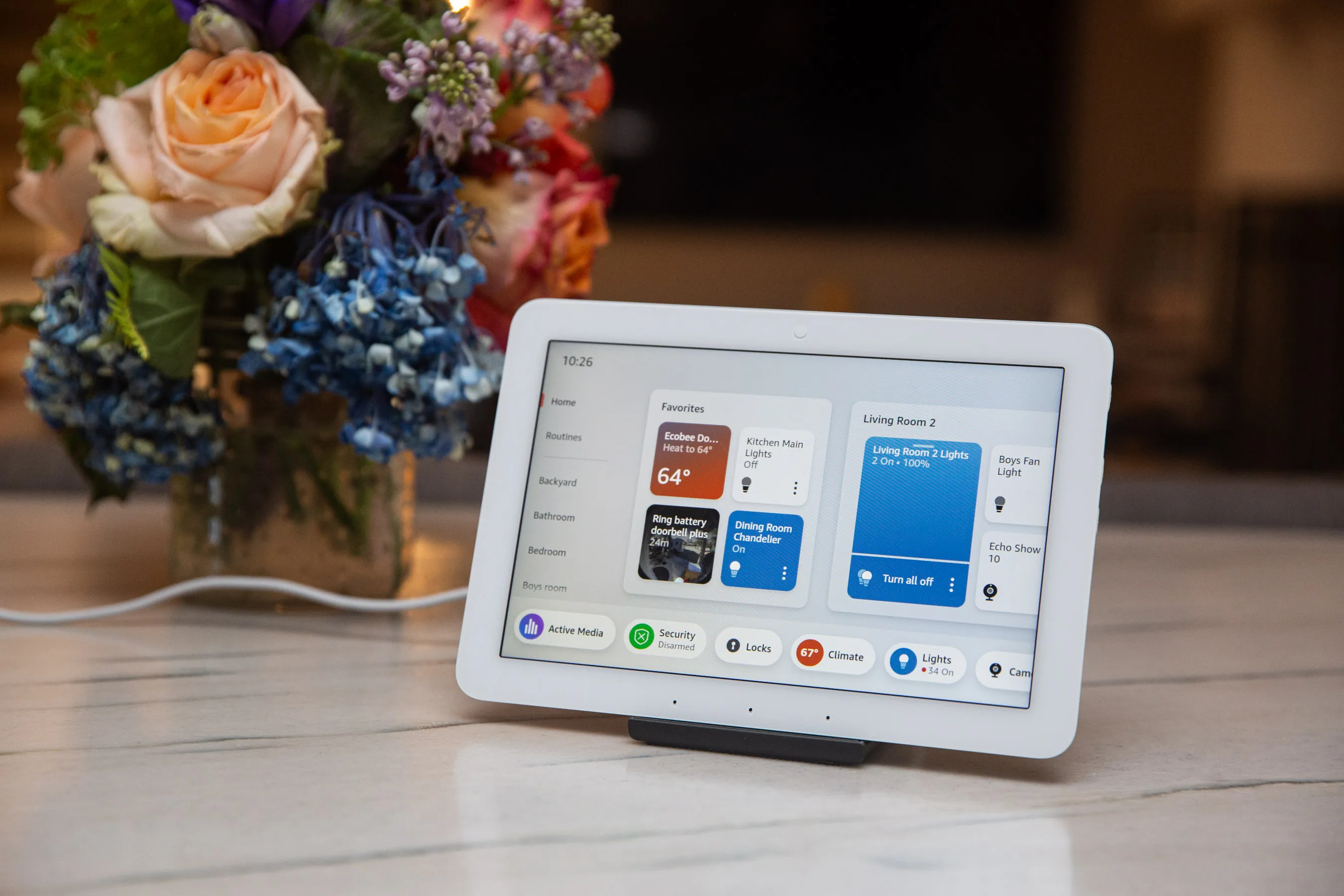 Çiçeklerin yanında bir tezgah üzerinde küçük bir dokunmatik tablet.